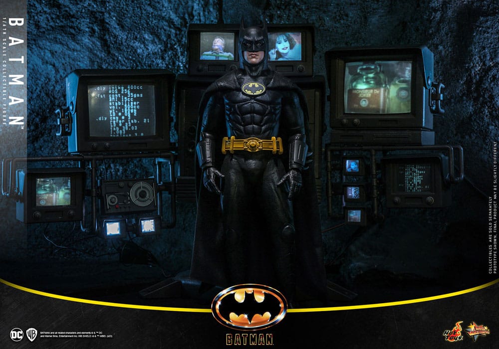 Figura Batman Hot Toys frente a paneles del Batcueva con luces y pantallas