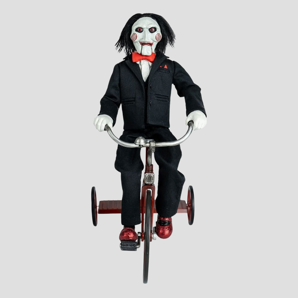 Vista frontal de Billy the Puppet con traje negro y triciclo rojo.