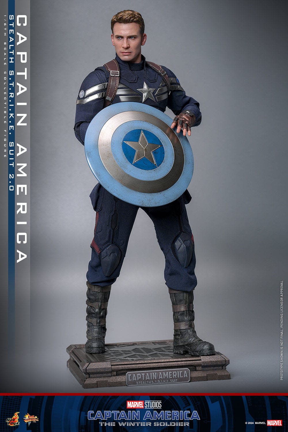 Vista frontal de la figura Capitán América Hot Toys con base expositora