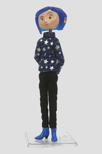 Figura articulada de Coraline Jones con cabello azul, suéter de estrellas, pantalón negro y zapatos azules, fabricada por NECA.