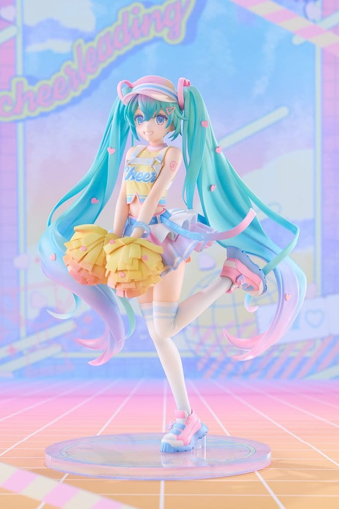 Figura Hatsune Miku Cheerleading Ver. de Good Smile Company, escala 1/7 y 25 cm, con traje de animadora en tonos pastel, larga melena turquesa, pompones amarillos y pose dinámica.