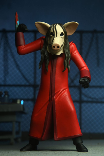Figura Jigsaw Killer de Saw con túnica roja, máscara de cerdo y cuchillo, perteneciente a la línea Toony Terrors de NECA.