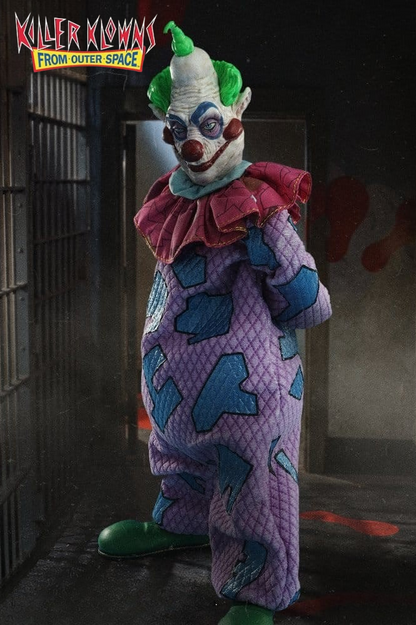 Figura de Jumbo de Killer Klowns from Outer Space, fabricada por Mezco Toyz para la línea One:12 Collective, de 17 cm, con traje de payaso morado y azul, cabezas intercambiables y accesorios circenses.