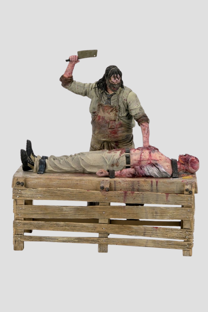 Diorama Slaughterhouse de Leatherface de NECA, perteneciente a La Matanza de Texas: El Origen, con figura de 18 cm, víctima sobre mesa de madera y accesorios de matadero.
