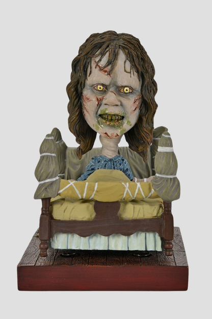 Figura Head Knocker de Regan poseída en la cama de El Exorcista, fabricada por NECA e inspirada en la clásica película de terror.