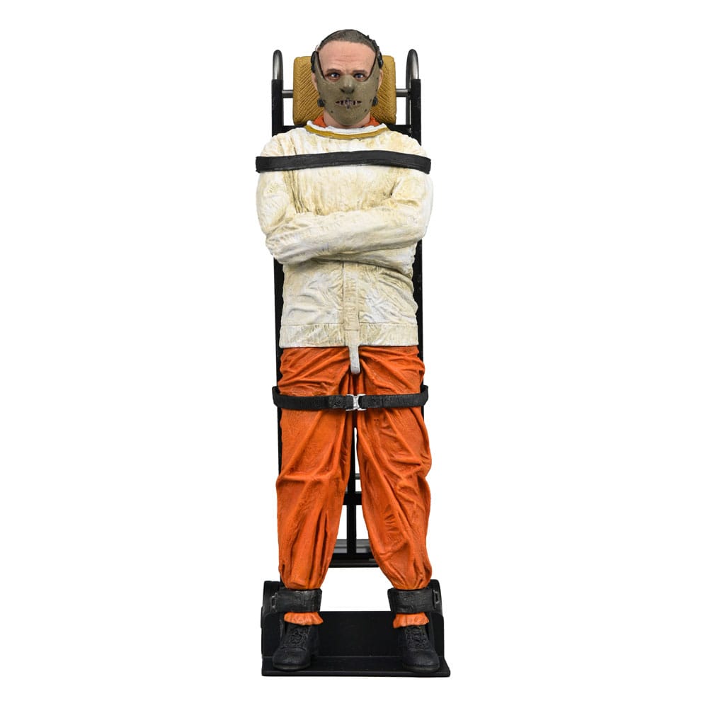 Figura lateral de Hannibal Lecter amarrado a camilla, con traje naranja y camisa de fuerza.