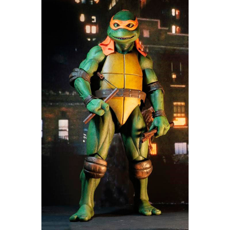 Michelangelo articulado de NECA en caja con ventana, incluye accesorios.